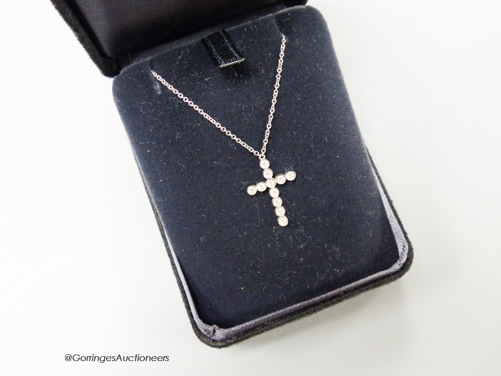 A modern Tiffany & Co platinum and diamond set cross pendant necklace, pendant 18mm, chain 40cm, gross weight 3 grams, with Tiffany box.